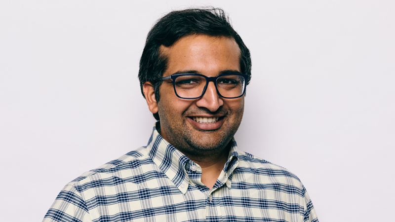 Rajiv Khanna smiling against a light background
